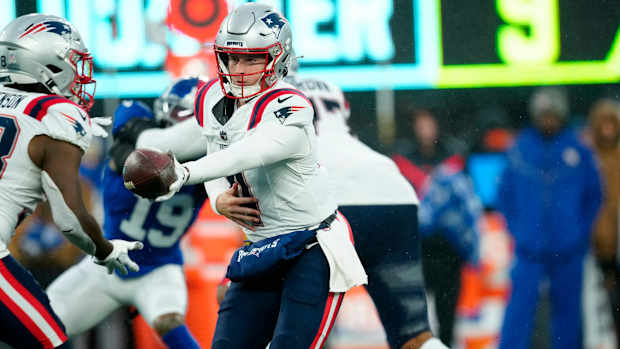 New England Patriots quarterback Bailey Zappe (4) prepares to handoff to New England Patriots running back Rhamondre Stevenson (38) 